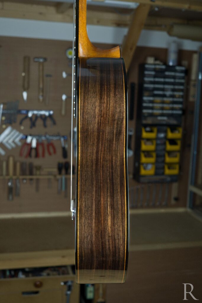 Side of handmade classical guitar in ebony and Indian rosewood